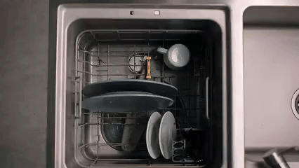 Person loading dishes into FOTILE in-sink dishwasher